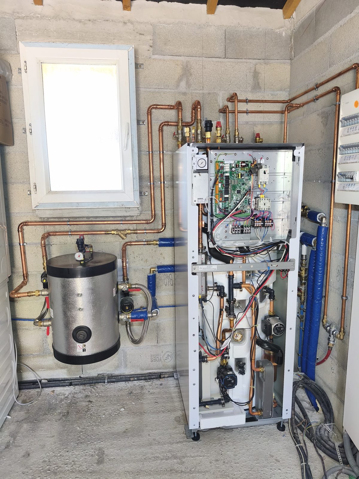 Module intérieur d'une pompe à chaleur air-eau, capot ouvert : carte de régulation, protection électrique, circulateur et échangeur, raccordé en cuivre — installation MSC Climatisation dans le Var.