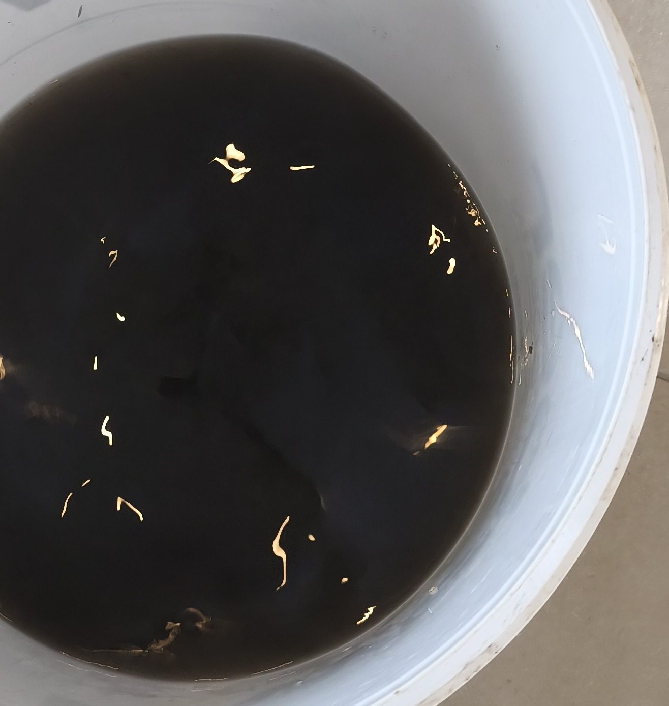 Seau d'eau noire récupérée après le rinçage d'une unité murale — MSC Climatisation